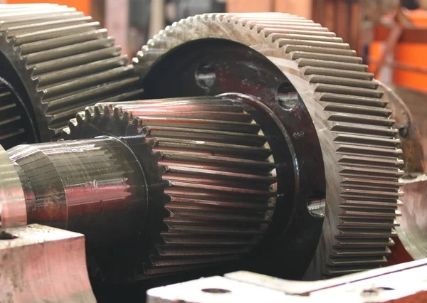 What are the common causes of abrasive wear on gear teeth?